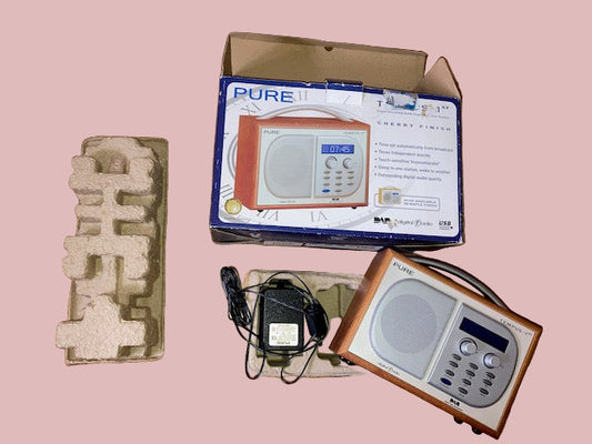 Pure II radio with packaging and accessories on a wooden surface